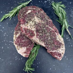 A piece of meat with herbs on it