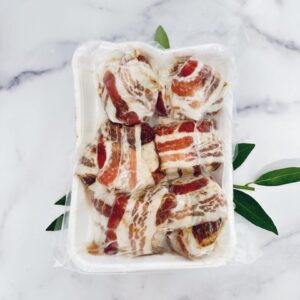 A white container filled with bacon wrapped meat.