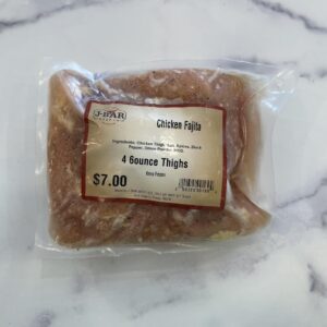 A package of chicken thighs on top of a counter.